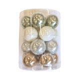 Clear cylindrical container with green, white, and gold Christmas balls on a white background